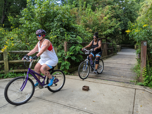 Two people riding a bike on Riverwalk