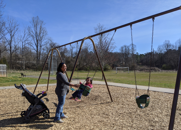 Mother and child on swing set at Gold Park.