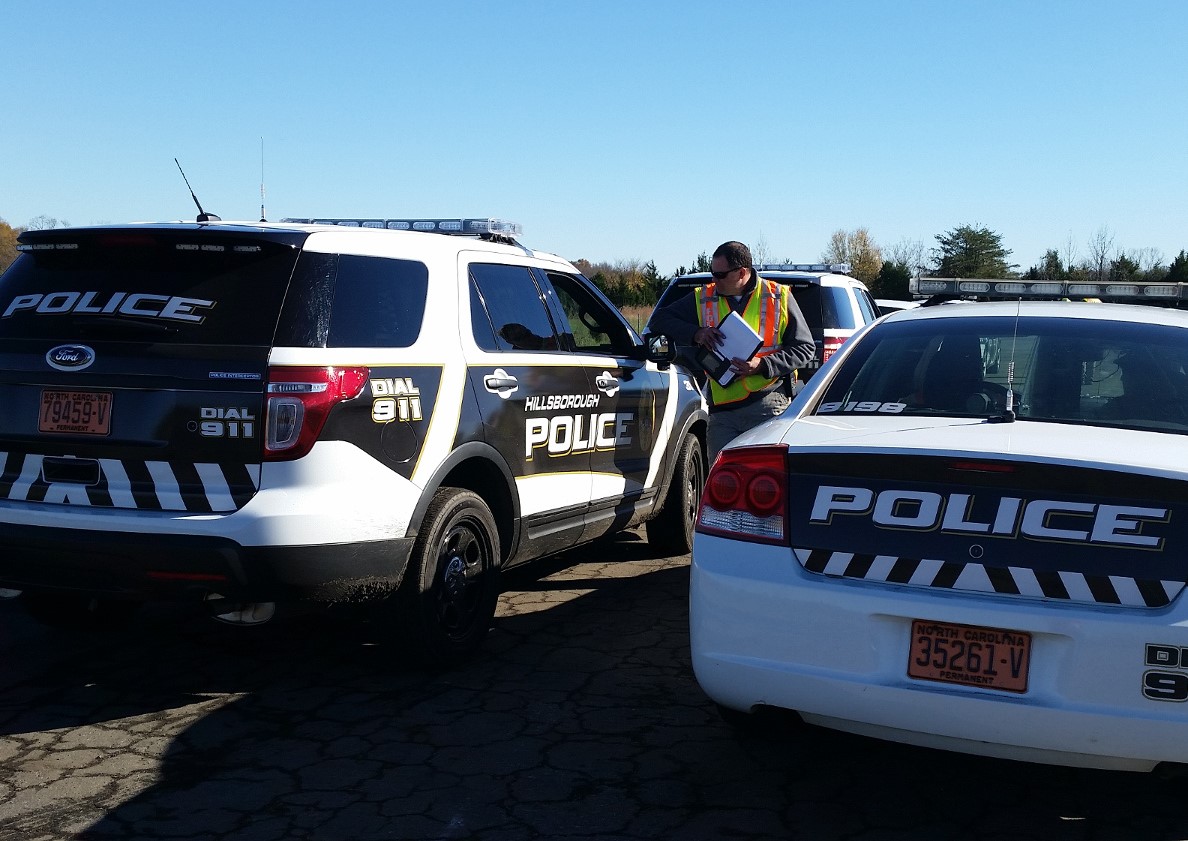 Police chief gives instructions for driver training to officers in two vehicles